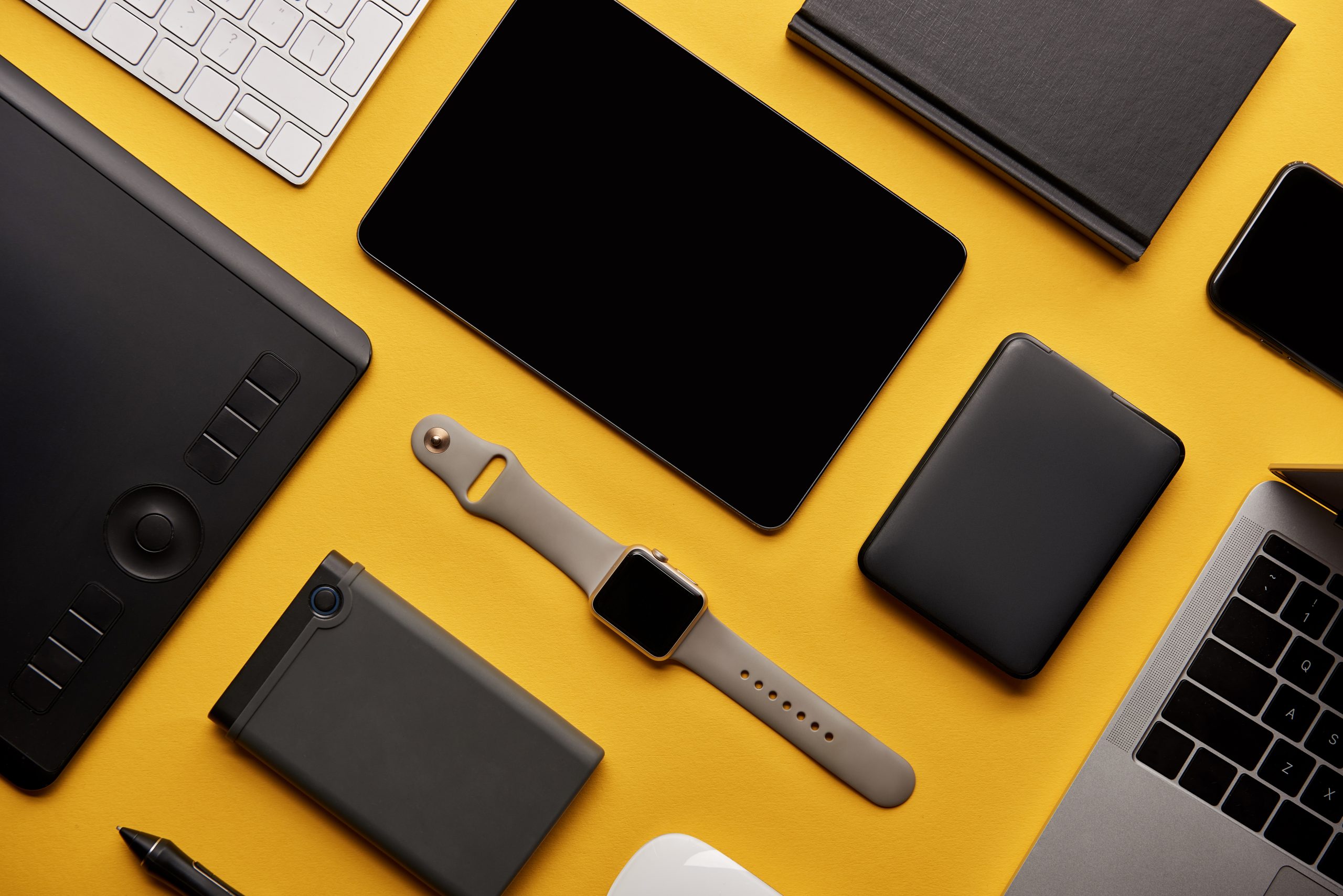 flat lay with different wireless devices on yellow surface