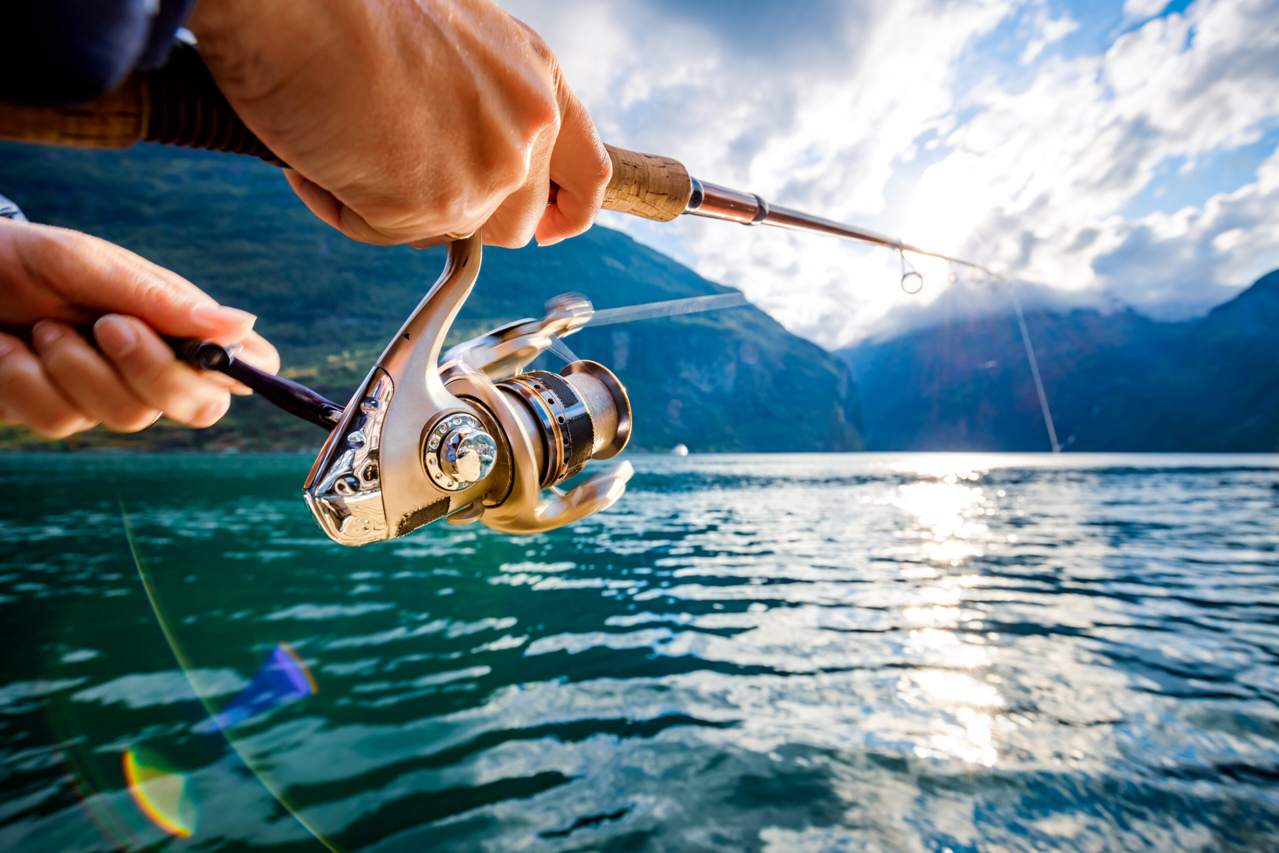 Woman fishing on Fishing rod spinning in Norway. Fishing in Norway is a way to embrace the local lifestyle. Countless lakes and rivers and an extensive coastline means outstanding opportunities...