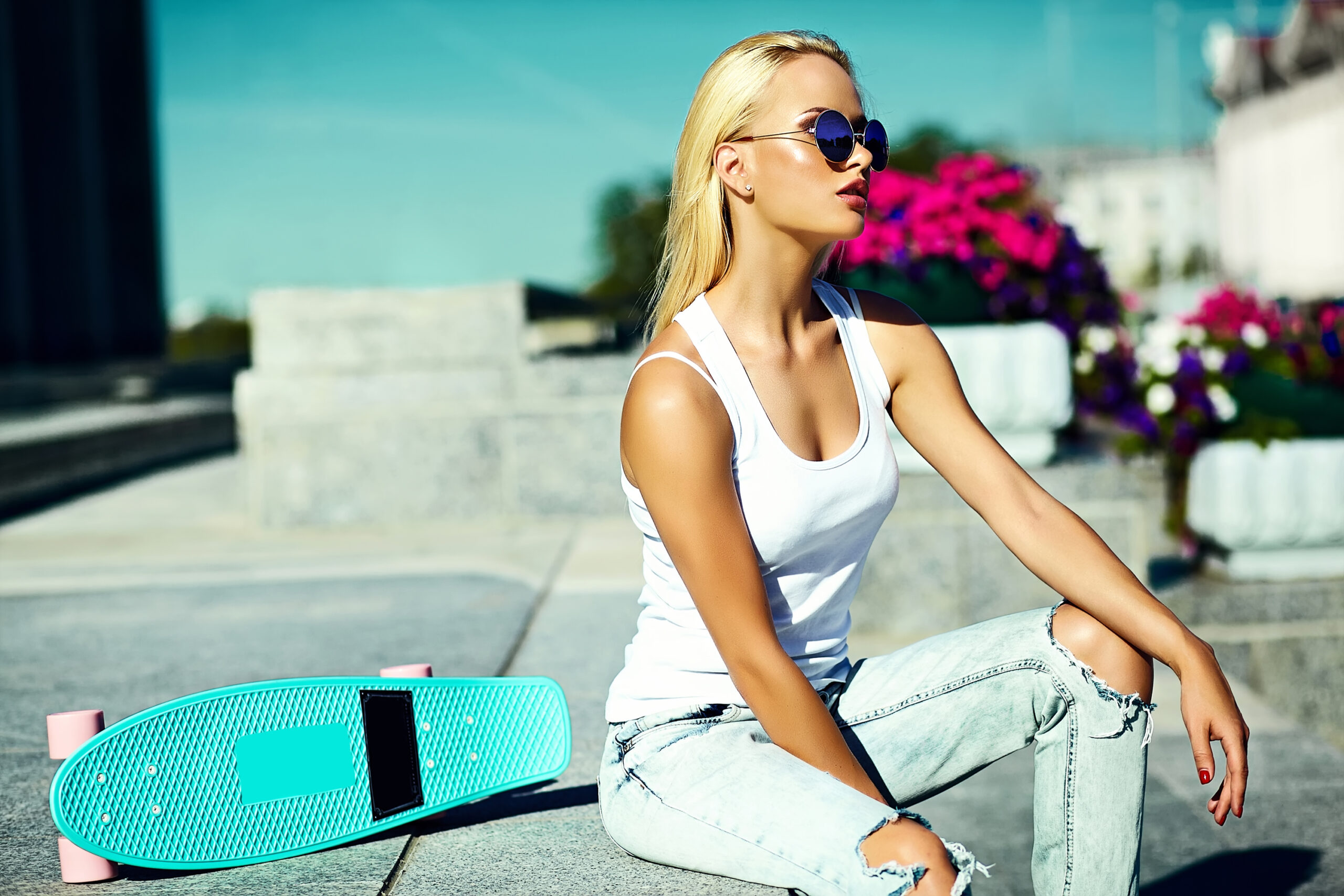 High fashion look.glamor stylish sexy beautiful young blond  model girl in summer bright casual hipster clothes with skateboard behind blue sky in the street