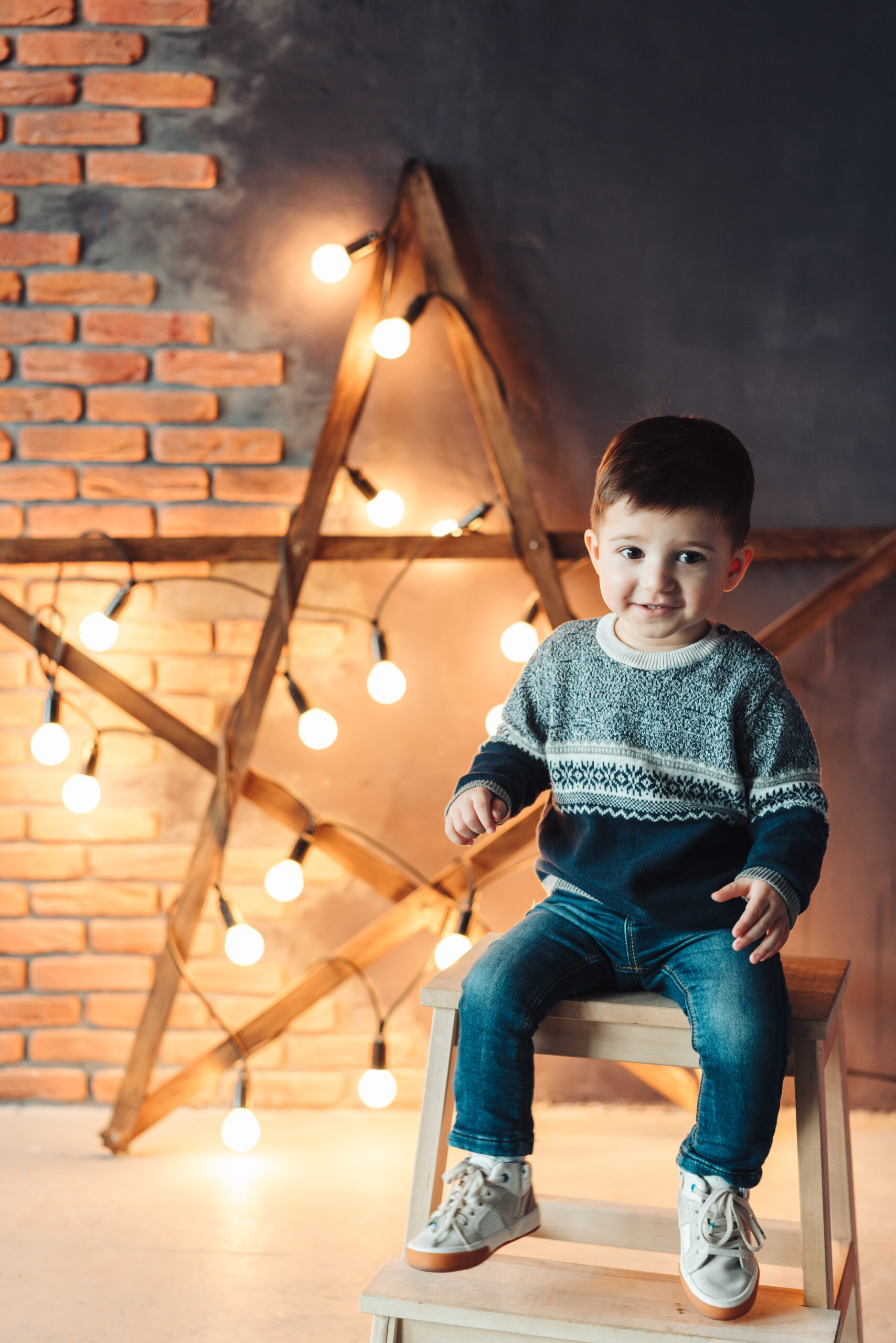 little boy sitting on a chair and looking at the camera